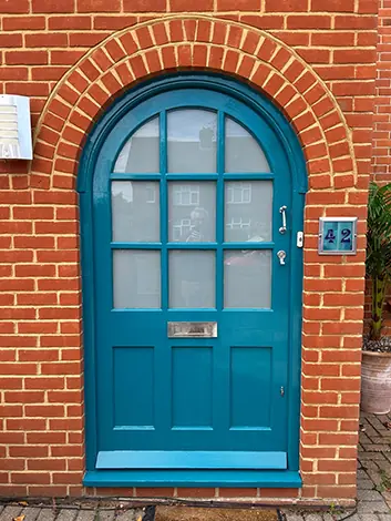 Front door freshly painted in dark teal