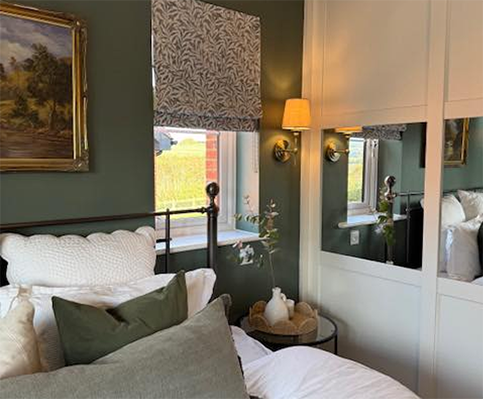 A bedroom painted in dark sage green with professional finish