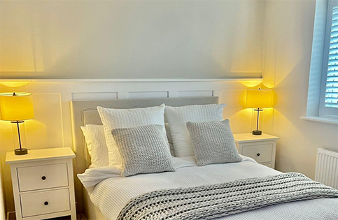 A light off white bedroom with lower white panelling showing quality craftsmanship