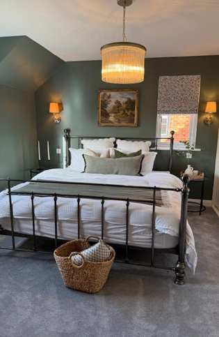 A dark sage green bedroom freshly decorated with expert painting techniques