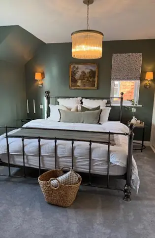 A dark sage green bedroom freshly decorated with expert painting techniques
