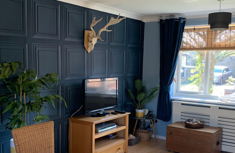 Lounge with dark blue geometric wallpaper showing precise installation